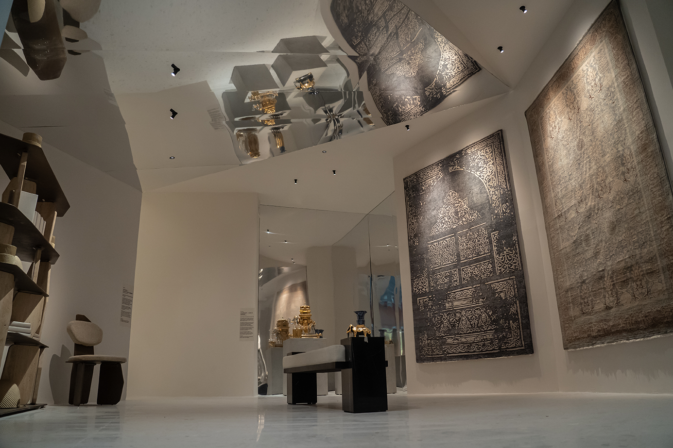 Interior view of the AFTER LIFE exhibition with reflective ceiling and curated objects