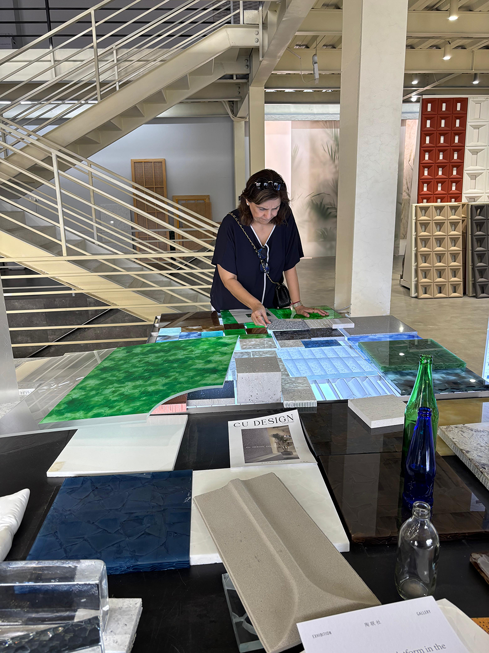 Monika Choudhary examining material samples at a design exhibition.