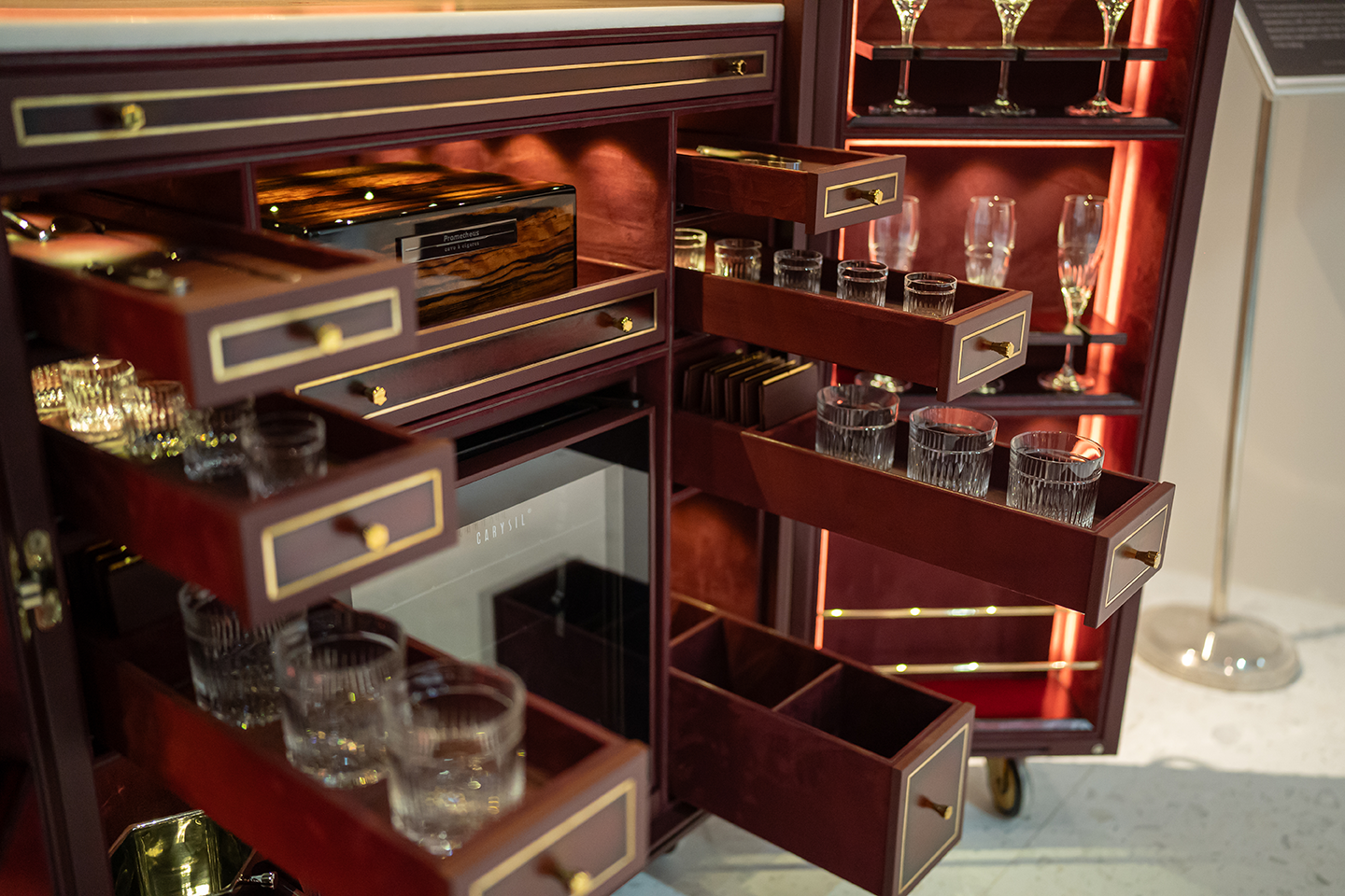 Ornate wooden cabinet with drawers and glassware at the AFTER LIFE exhibition
